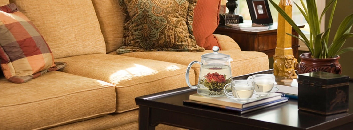 Blooming tea, steeping in a glass teapot on a dark brown coffee table