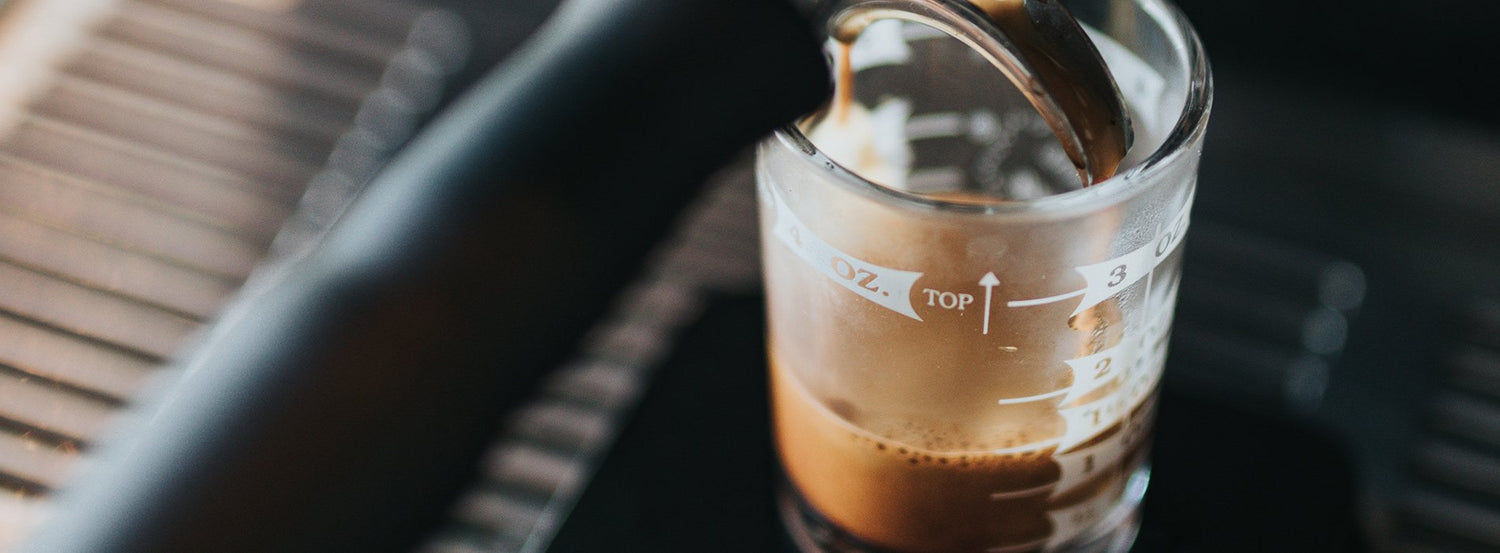 A clear espresso measuring cup filling up with espresso made witih Segafredo Zanetti coffee.
