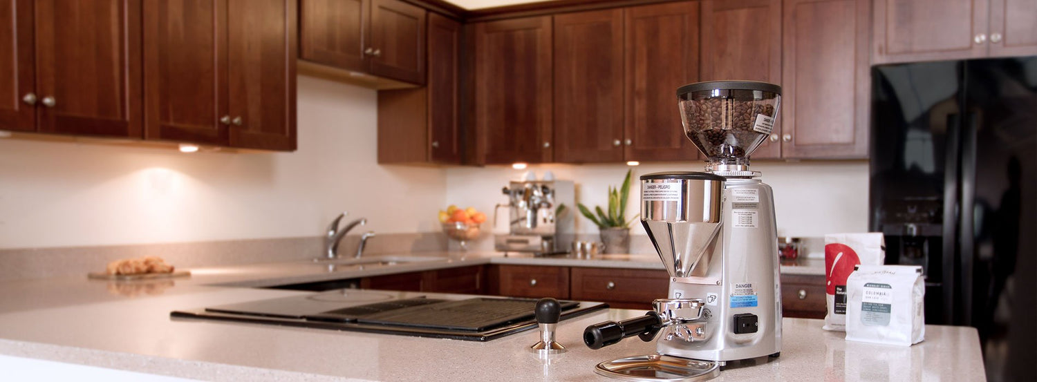 A Mazzer coffee and espresso grinder in a modern home kitchen