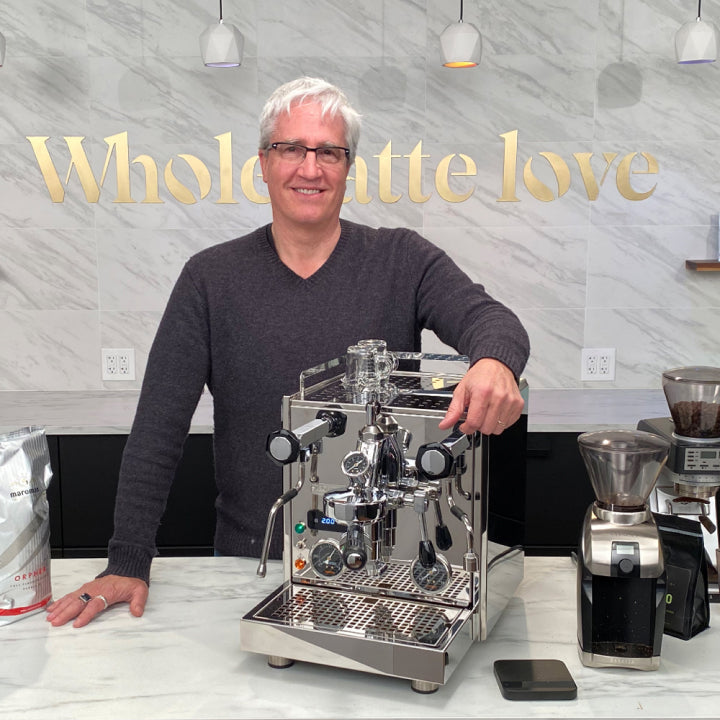 Gary Salzman with arm over espresso machine.