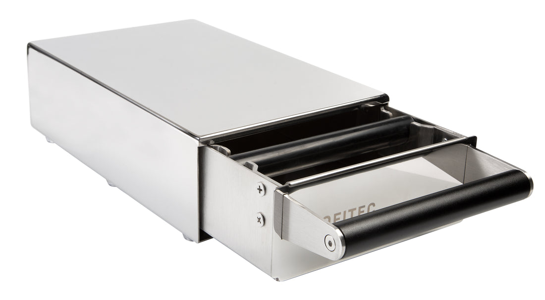 A polished stainless steel Profitec Knock Drawer with a black silicone-coated knock bar, featuring the Profitec logo engraved below the handle. || Polished Steel