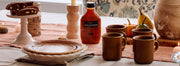 Fall table setting with Kinto Mugs, Hollander Sauce and a pie on a table with other decorations.
