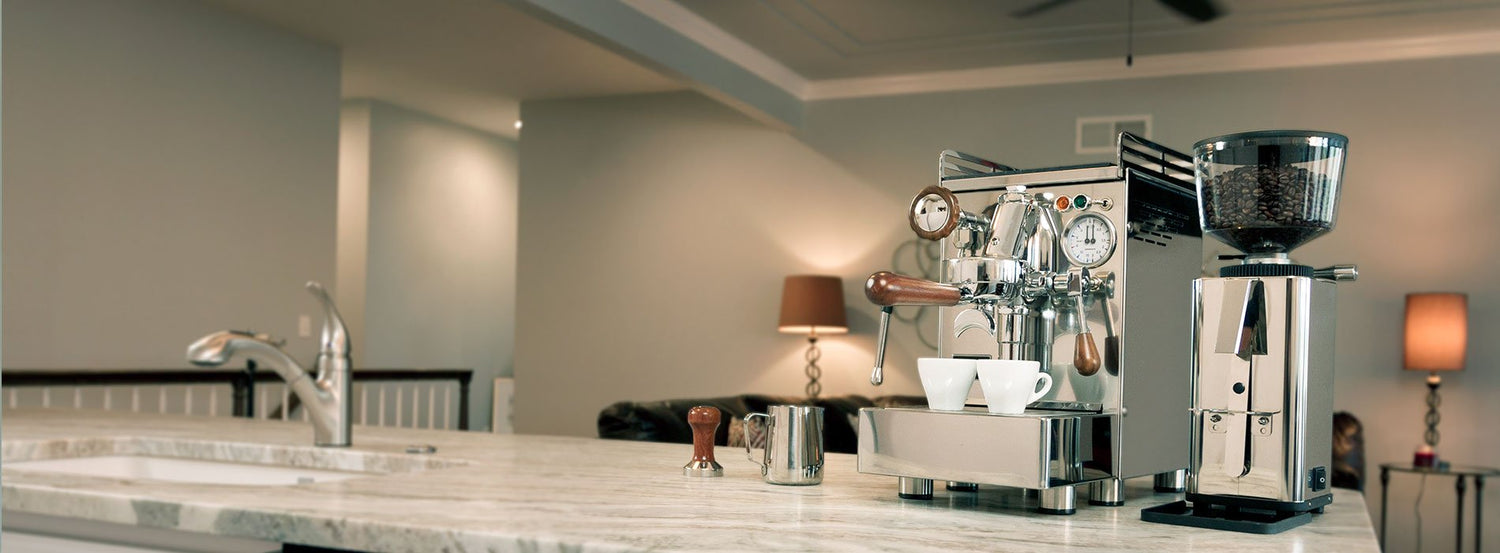 A 969.coffee Elba 3 espresso machine on a kitchen counter next to a coffee grinder, tamper, and milk frothing pitcher.