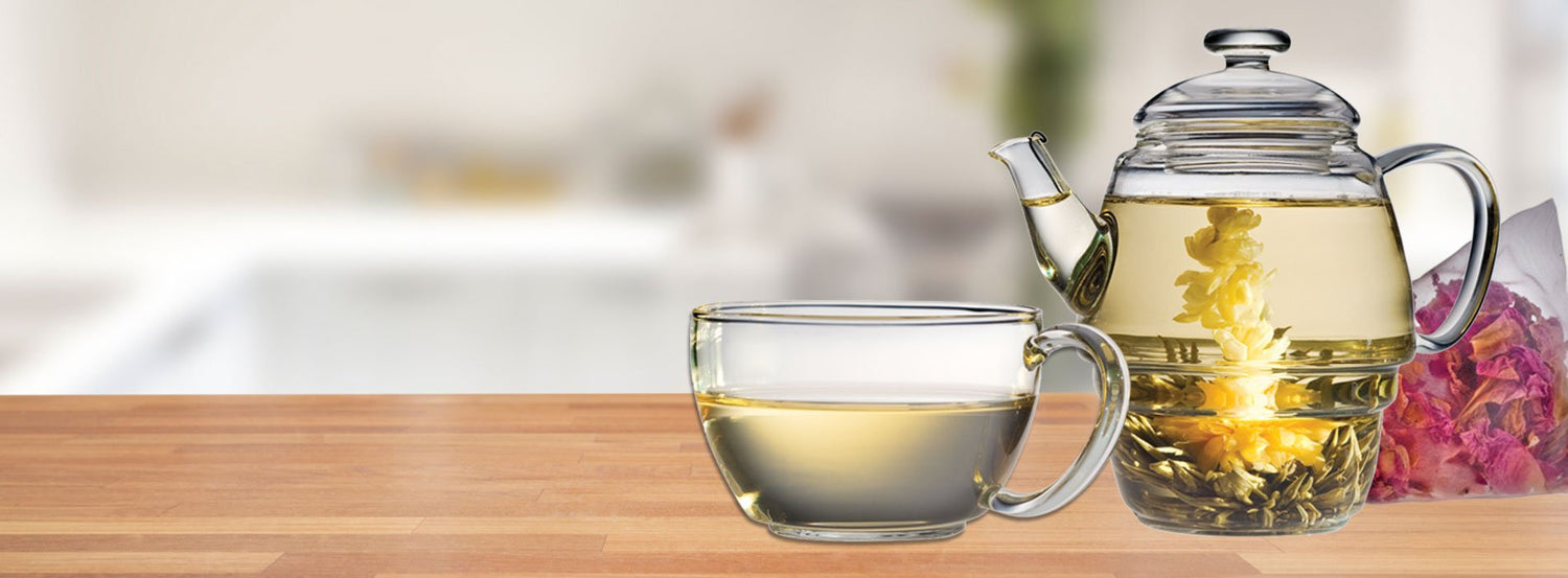 A glass tea brewer filled with water and blooming tea.