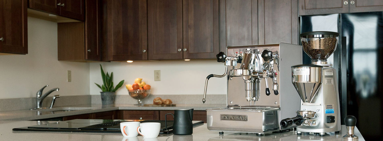 An Expobar espresso machine on a kitchen counter, surrounded by dark brown cabinetry.