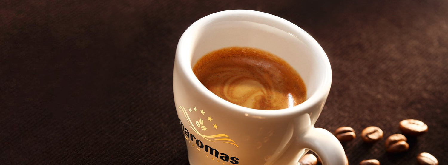 Espresso in a white espresso cup emblazoned with the Maromas Coffee brand logo