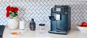Gaggia Cadorna Milk on a kitchen counter with flowers and a bottle of Hollander chocolate sauce.