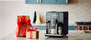 Close-up of a Gaggia Accademia Super-Automatic machine on a kitchen counter next to a holiday present.