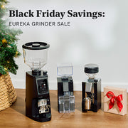 Eureka grinder sale with coffee grinders and on a wooden surface.