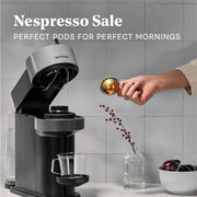 Nespresso coffee machine with a hand adding coffee pods to it, against a gray tiled wall. Promotional text that reads Nespresso Sale - Perfect pods for perfect mornings.