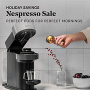 Nespresso coffee machine with a hand adding coffee pods to it, against a gray tiled wall. Promotional text that reads Nespresso Sale - Perfect pods for perfect mornings.