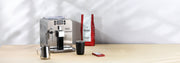 Gaggia Brera in Silver next to a bag of Gaggia Milano Intenso Coffee a cup, cleaning tablets and a milk frothing pitcher.