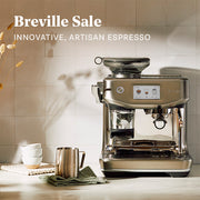 Breville Barista Touch machine on a kitchen counter next to coffee accessories. Promotional text above that reads "Breville Sale!".