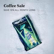 Bag of Whole Latte Love Beaned UP laying in snow with promotional text that reads "Coffee Sale - save 10% all month long".