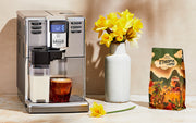 Close-up of a Gaggia Anima Prestige on a brown and white counter top next to flowers and Whole Latte Love Ethiopia Limmu Whole Bean Coffee bag.
