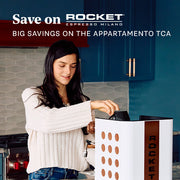Woman using a White Rocket Appartamento TCA with Copper in a kitchen. Promotional text overlayed that reads "Save on Rocket Espresso - Big savings on the Appartamento TCA".