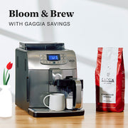 Gaggia Velasca Prestige on a wooden surface next to a bag of Gaggia Intenso Coffee. Promotional text that reads "Bloom & Brew with Gaggia Savings".