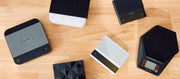 Close-up of various varia, brewista and acaia scales laid out on a wooden counter top.