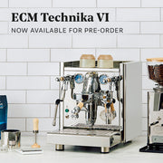 ECM Technika VI in Stainless Steel with Tiger Maple accents next to an ECM grinder and other accessories on a white counter in front of a white tile wall. Promotional text overlayed that reads "ECM Technika VI - Now available for pre-order".