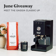 Gaggia Classic UP in Black on a white counter next to a Whole Latte Love mug and Gaggia Intenso Coffee Beans. Promotional text overlayed that reads "June Giveaway - Meet the Gaggia Classic UP".