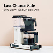 Technivorm Moccamaster in white on a white counter in front of a light pink background. Promotional text overlayed reading 'Last Chance Sale SAVE BIG WHILE SUPPLIES LAST'.