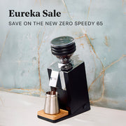 Eureka Speedy 65 in Black on white counter grinding beans. Promotional text overlayed that reads "Eureka Sale - Save on the New Zero Speedy 65".