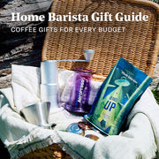 Basket outside with an AeroPress, Whole Latte Love Beaned UP, Varia FLO Dripper and Varia Hybrid Hand Grinder inside. Promotional text overlayed that reads "Home Barista Gift Guide - Coffee Gifts for Every Budget".