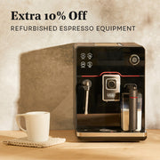 Gaggia Accademia in Black Glass next to a white mug on a brown counter top in front of a gray and black wall. Promotional text overlayed that reads "Extra 10% Off Refurbished Espresso Equipment".