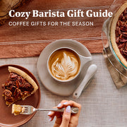 A cozy coffee-themed gift scene with a cup of latte art coffee on a saucer, a slice of pecan pie on a plate, a hand holding a fork with coffee, and a pie dish at the side. Large text at the top reads 'Cozy Barista Gift Guide' and 'COFFEE GIFTS FOR THE SEASON'.