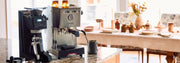 Etzinger etzMAX LT in Black next to a Gaggia Classic GT on a granite counter top with a fall table setting in the background.