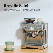 Breville Barista Express in Stainless Steel on a wooden counter top in front of a white tiled wall next to a sage cup. Promotional text overlayed that reads "Breville Sale! Innovative, Artisan Espresso".