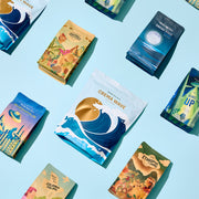 Various Whole Latte Love coffee packages with different designs on a blue background.