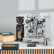 Profitec Pro 500 Espresso machine next to a Profitec A54 Twist grinder and accessories on a white surface.