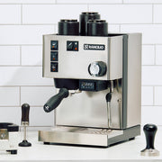 Rancilio silvia coffee machine on a white tiled wall background.