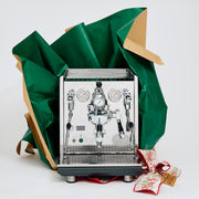 ECM Synchronika II Espresso machine wrapped in green paper with a red ribbon on a white background