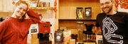 A man and a woman standing next to their prize winnings of coffee and machines from the Ugly Duck Lunar New Year latte art throwdown.