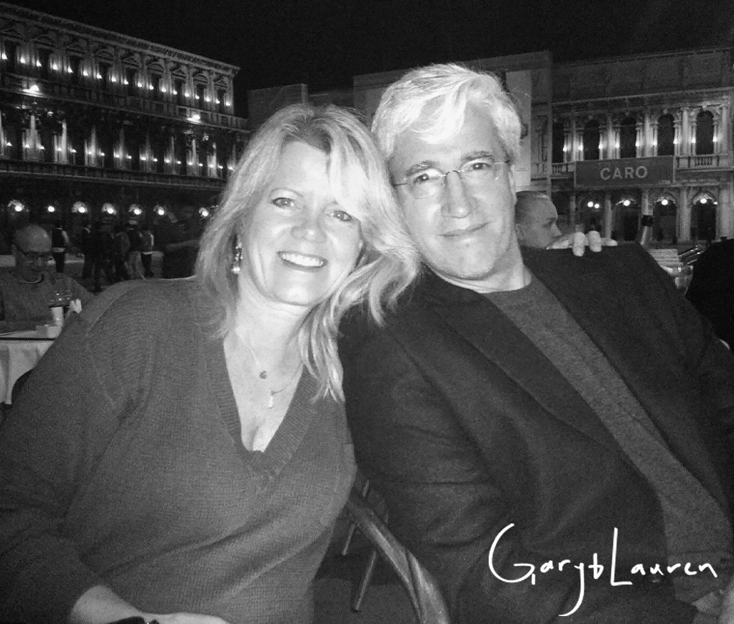 Black and white photo of Gary and Lauren Salzman (owners of Whole Latte Love) sitting together at a table with a blurred background.