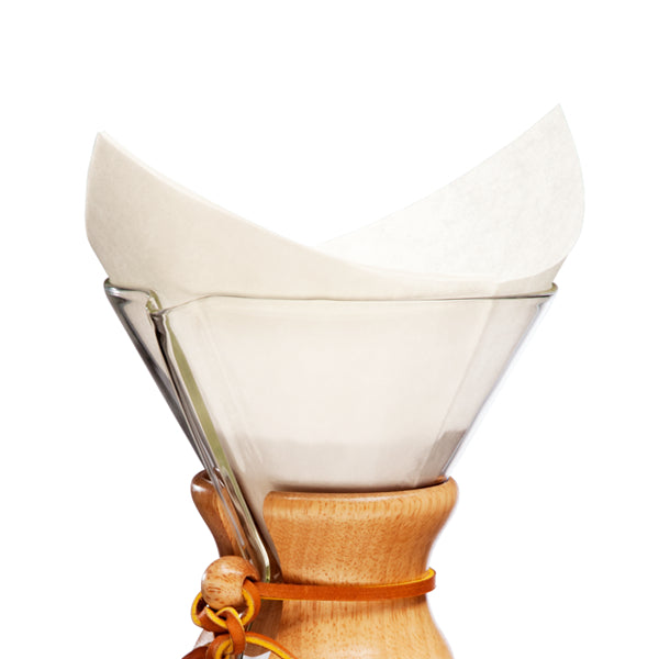 A Chemex pre-folded filter square resting in a Chemex coffee maker